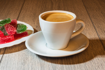 Cup of coffee and multi-colored marmalade.