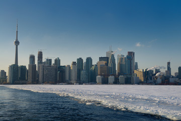 Obraz premium Toronto city skyline in winter from ice breaking path of Wards Island Ferry on frozen Lake Ontario