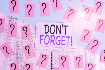 Conceptual hand writing showing Don T Forget. Concept meaning used to remind someone about important fact or detail Crumbling papers with thick cardboard on the wooden table