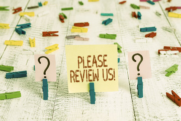 Writing note showing Please Review Us. Business concept for situation or system is formal examination by showing authority Crumbling sheet with paper clips placed on the wooden table