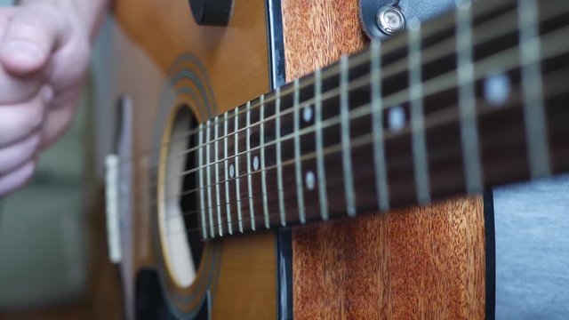 Coustic guitar in man's hands. Concert band on stage