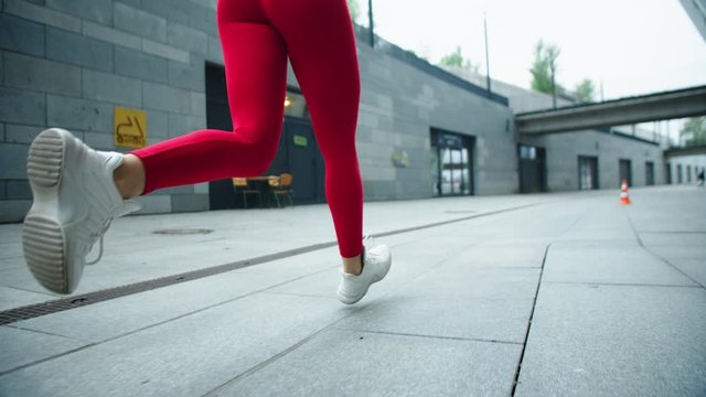 Female legs running on urban street. Closeup woman legs running outdoor