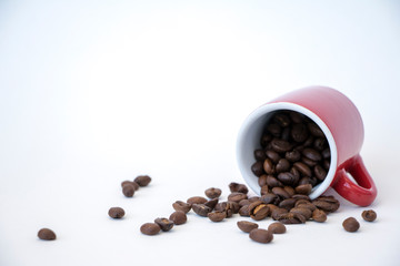 Espresso cup with spilling coffee beans