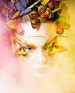 woman with summer creative make up like fairy butterfly closeup bright colored background