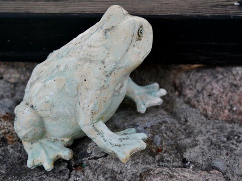 Steinfrosch als Dekofigur im Garten