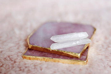 Rose quartz coasters with two small crystals. Mystical altar on pink background. 