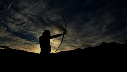 Die Silhouette eines Bogenschützen bei Sonnenuntergang