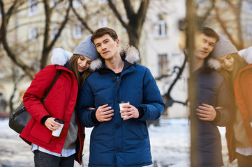 A trendy young couple walks in the city at christmastime