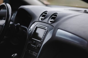 Modern car interior. Steering wheel, gearshift lever, multimedia system, driver's seat and dashboard.