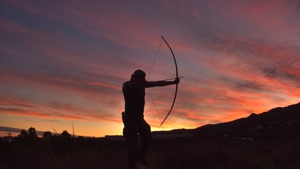 Die Silhouette eines Bogenschützen bei Sonnenuntergang