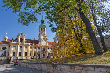 PRAGUE, CZECH REPUBLIC - OCTOBER 14, 2018: The Loreto baroque church and autumn tree.