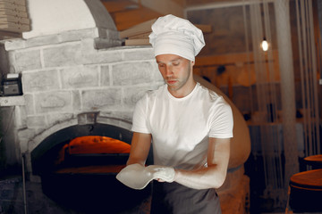 Chef prepare the pizzaa. Man in a white uniform