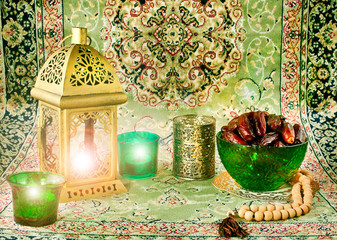 Ramadan lamp, candles with dates in green bowl and rosary.