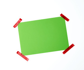 blank green sheet of paper stuck with red sticky tape