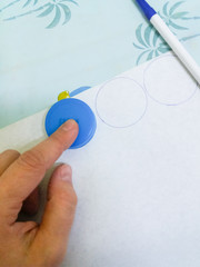We make crafts with the children - we circle the circles for the New Year's garland on a plastic cap from a large bottle