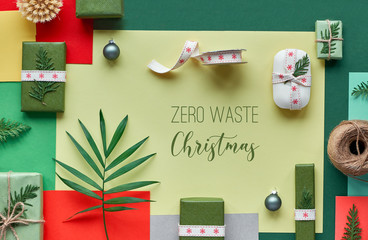 Eco friendly zero waste products wrapped as Christmas or New Year gifts without plastic. Creative flat lay, top view of zero waste Christmas gift ideas, multicolor geometric paper background, text.