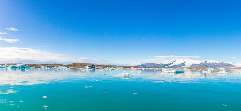 Panoramic pictures over Joekularson glacier lagoon with frifting iceberg in summer