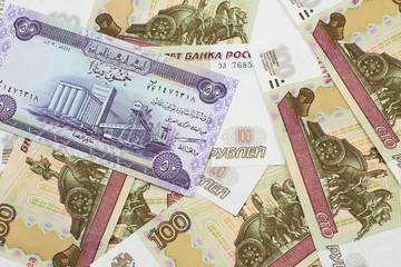 A purple Iraqi fifty dinar bank note close up in macro with an assortment of Russian one hundred...