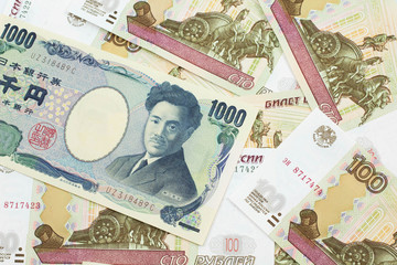 A one thousand Japanese yen bank note close up in macro with Russian one hundred ruble bills