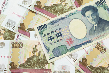 A one thousand Japanese yen bank note close up in macro with Russian one hundred ruble bills