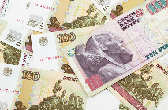 A close up image of an Egyptian ten pound bank note with Russian one hundred ruble bills in macro