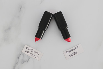 beauty industry competition, two identhical looking lipsticks with Original Product and Product Dupe labels