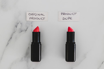 beauty industry competition, two identhical looking lipsticks with Original Product and Product Dupe labels