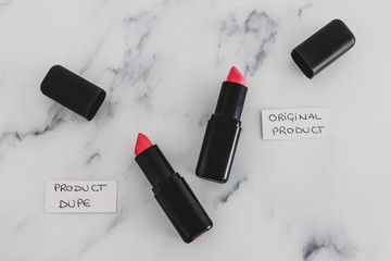 beauty industry competition, two identhical looking lipsticks with Original Product and Product Dupe labels