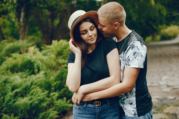 Lovely couple in a summer park. Boy with his girlfriend. Girl in a brown hat.