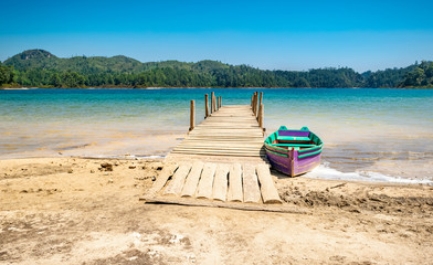 Sandy beach and a colorful boat at one of the Montebello Lakes National Park (Parque Nacional Lagunas de Montebello) in Chiapas, Mexico, near Guatemalan border. 