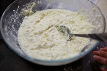 Baking domestic rolls with cheese. Putting cheese on dough for rolls