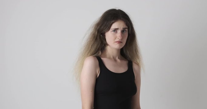 Disgusted young woman repulsing something over white background