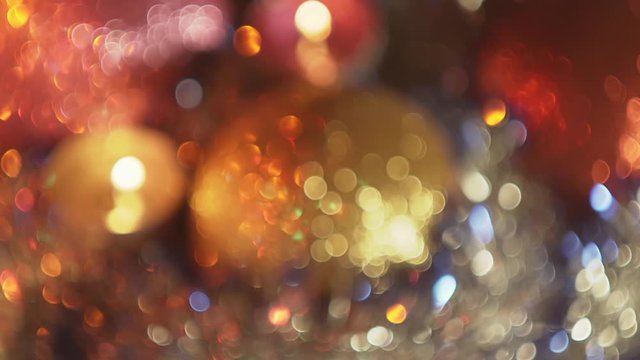 Beautiful abstract festive background with rotating Christmas shiny blurry decorations and bokeh candles flame.