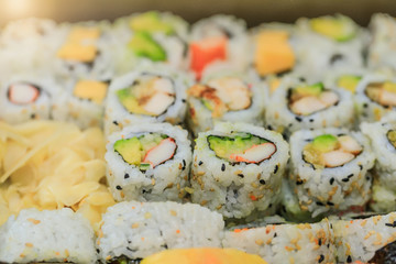 Top view if sushi rolls with salmon, avocado, tuna and cucumber. Maki plate with rice and nori. Delicious Japanese food with sushi roll in close up picture. Healthy kale and sushis. 