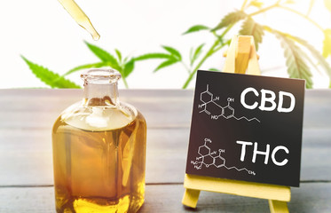 Cannabis oil in glass bottle and chalkboard with molecule drawing of THC and CBD