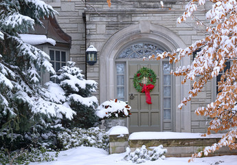 Front door of snow covered house with Christmas wreath © Spiroview Inc.