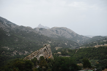 Breathtaking landscape of summer mountains on cloudy sky background. Photography with amazing forested hills and giant rocks.