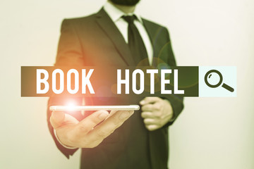 Handwriting text Book Hotel. Conceptual photo an arrangement you make to have a hotel room or accommodation Male human wear formal work suit hold smart hi tech smartphone use one hand