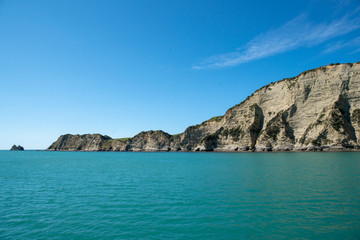 Fototapeta na wymiar Dramatic rugged rock cliff face on the headland at the coast