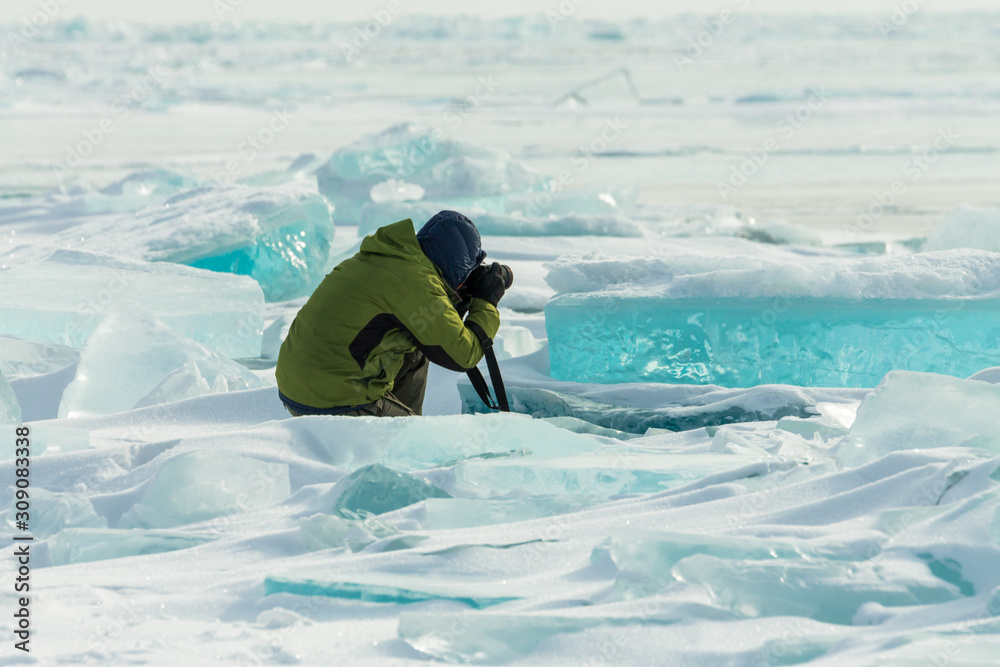 Wall mural photographer takes pictures frozen clear ice in winter lake baikal, russia