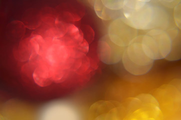 Shiny abstract background with festive defocused lights, red and gold bokeh. Christmas or New Year...