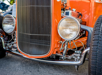 Epic vintage orange retro car with open wheel suspension and headlights on the sides of the car body