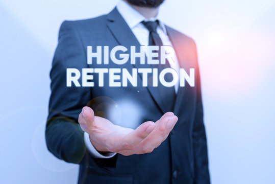 Conceptual hand writing showing Higher Retention. Concept meaning ability of an organization to retain its employees Male human with beard wear formal working suit clothes hand