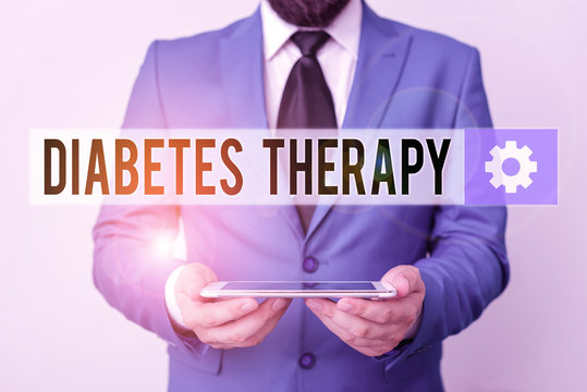 Text sign showing Diabetes Therapy. Business photo text aim to achieve lower average blood glucose results Businessman in blue suite with a tie holds lap top in hands