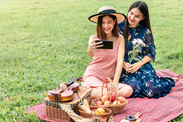 Sweet moment of love.Portrait of Asian homosexual couple funny selfie and picnic in the park.Concept LGBT leasbian.