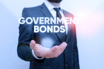 Conceptual hand writing showing Government Bonds. Concept meaning debt security issued by a government to support spending Male human with beard wear formal working suit clothes hand