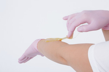Hands in rubber gloves close-up. doctor puts wax, honey. medic is preparing for depilation. Concept of medicine, health care, beauty industry, hair removal, natural material. Copy space