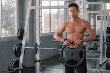 Fototapeta premium caucasian strong man doing exercise with weight lifting in gym club