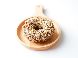 Homemade food fresh bakery, Isolated delicious chocolate donut almond peanut topping served on wooden dish on white kitchen table background