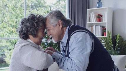 Happy couple old elderly senior man and woman hugging and touch with forehead, happy with smiling together at home, retirement and healthcare lifestyle and lover relationship concept